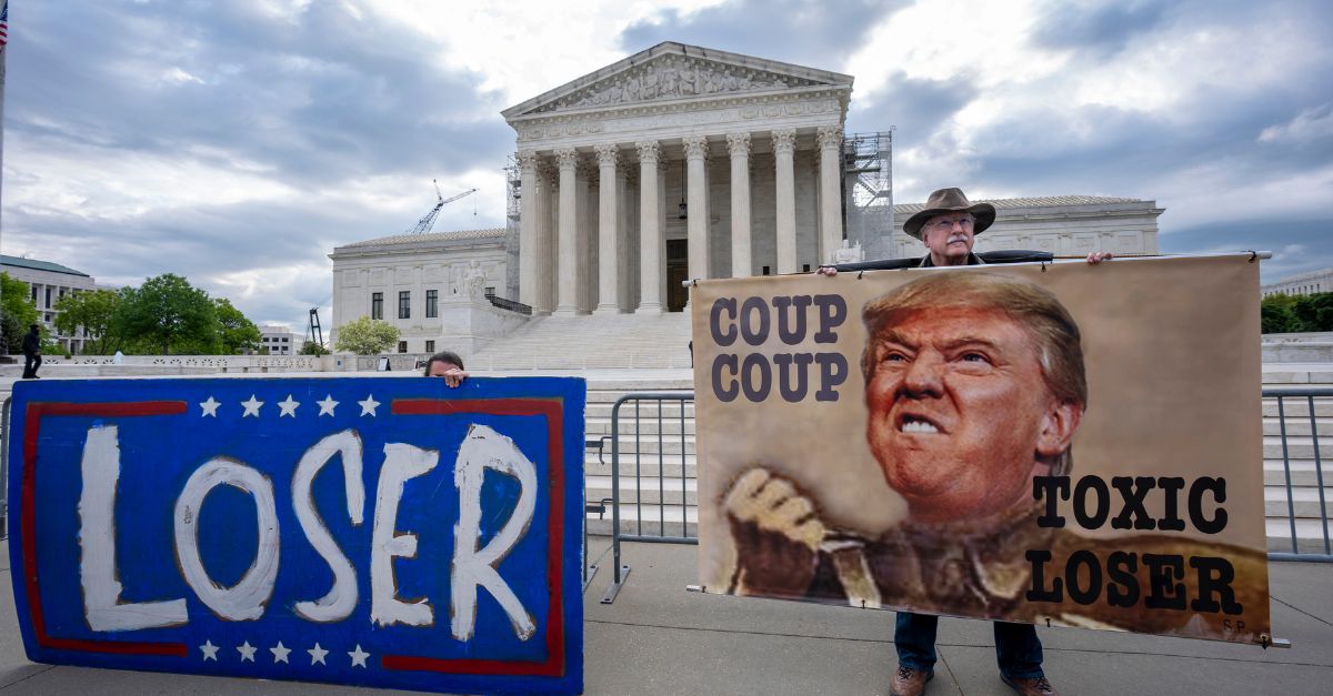 Activist Stephen Parlato of Boulder, Colo., right, joins other protesters outside the Supreme Court as the justices prepare to hear arguments over whether Donald Trump is immune from prosecution in a case charging him with plotting to overturn the results of the 2020 presidential election, on Capitol Hill in Washington, Thursday, April 25, 2024. (AP Photo/J. Scott Applewhite)